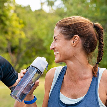 Group of adults with water bottle, exercising and smiling.