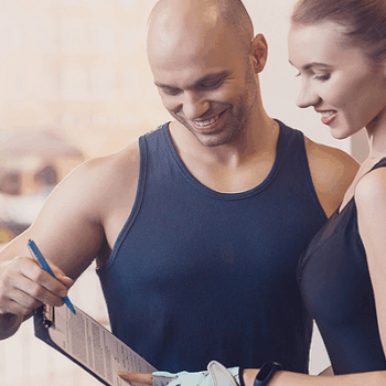 fitness instructor with a woman reviewing a workout plan